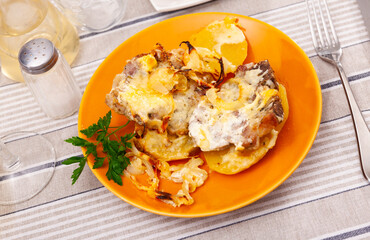 Appetizing pork with cheese and boiled potatoes on a plate