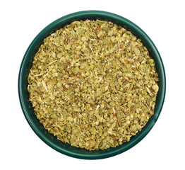  Close up pile, dried, chopped oregano leaves in bowl isolated on white, top view 