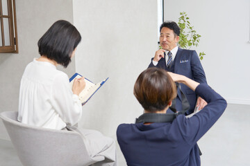 ビジネスマンにインタビューする女性記者