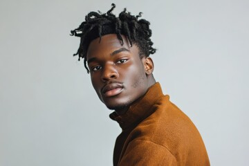 Obraz premium Stylish Young Man with Natural Hair Posing Against a Neutral Background