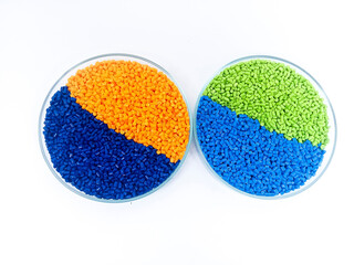 Masterbatch plastic, colorful polymer granules carrying pigments are poured into a glass cup with...
