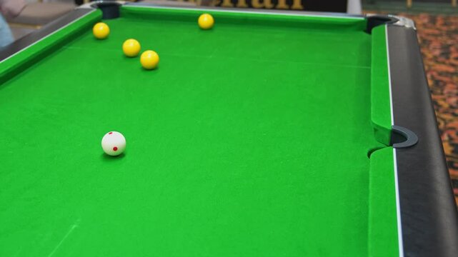 Wining the game by pocketing the black ball in blackball Pool game on a green cloth pool table, hit by the cue pocketing