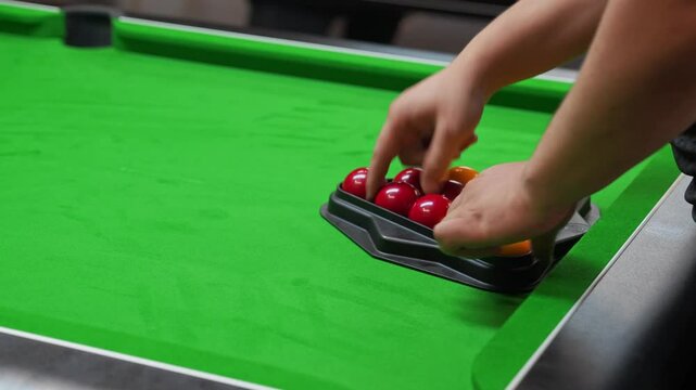 racking balls in triangle in blackball Pool game on a green cloth pool table, hit by the cue pocketing a red ball