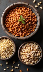 Fototapeta premium A rustic display of various types of nuts and seeds in bowls, highlighting their natural textures, colors, and a touch of green. Perfect for culinary and health-related projects.