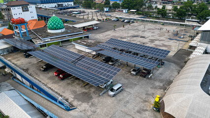 Solar panels are neatly installed on the rooftop of the parking area at Tirtonadi Terminal, efficiently harnessing sunlight amidst a busy urban landscape.
