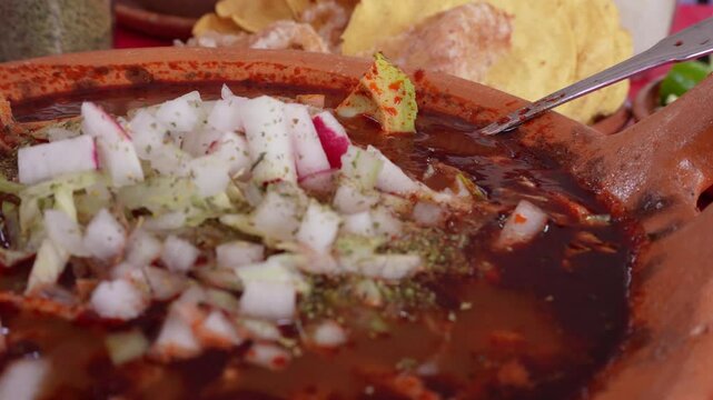 Paneo a palto de pozole preprado con cebeolla y rabano