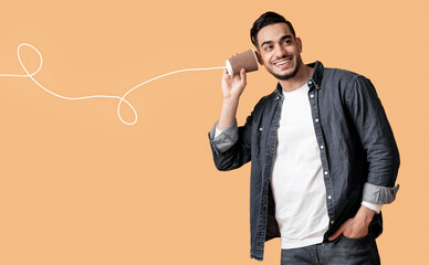 Romantic Arab Couple Communicating Through Tin Phone Over Yellow Background, Beautiful Middle Eastern Woman Sending Love Message Via Drawn String To Her Excited Boyfriend, Collage, Copy Space