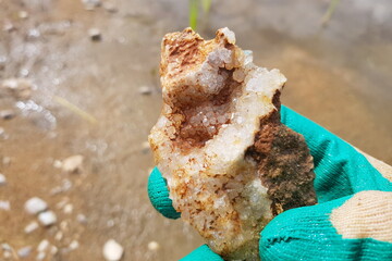 A fragment of a quartz geode in a hand during a search for rocks and minerals