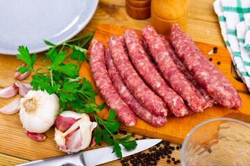 Traditional Catalan raw pork sausage longaniza ready for grilling on wooden board