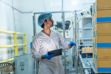 Inspector monitoring packaged goods near an automated robotic system in a factory. Focus on quality assurance, efficient logistics, and industrial automation.