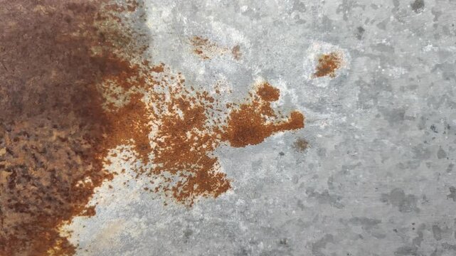 Rough rusty metal or zinc. This metal rusts due to exposure to sunlight and rainwater.