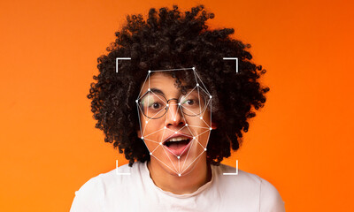 A person with a vibrant curly hairstyle and glasses expresses excitement against a bright orange...