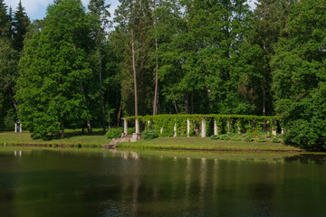 View of the pergola with a pier on the shore of the Chinese Pond in the Oranienbaum Palace and Park Ensemble on a sunny summer day, Lomonosov, Saint Petersburg, Russia