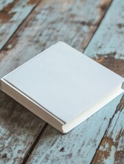 A white soft cover book lying on the table, birds eye view 