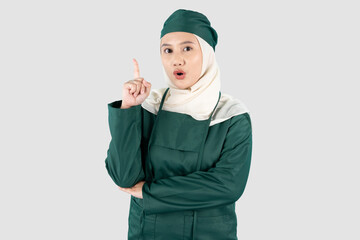 portrait of a female doctor wearing green surgical gets an idea and pointed her finger