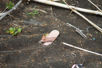 Photo of flip-flop trash on the beach sand.