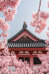 Naklejka premium Cherry blossoms frame a beautiful traditional temple in springtime elegance