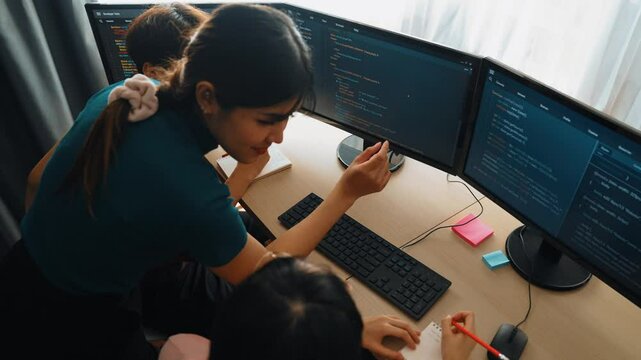 Slow motion back end software developer engineer for computer programming working together on debugging writing computing code, solving complex algorithms display on monitor in office. Burgeoning