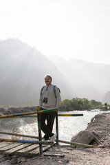 Senior man looking through binoculars on wooden walkway