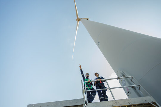 Team engineer wind turbine worker safety uniform survey discuss operational planning windmill field clean energy. Alternative technology protect environment reduce global warming problems.