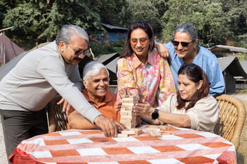 senior citizens playing with wooden blocks at comping side