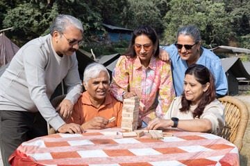 senior citizens playing with wooden blocks at comping side