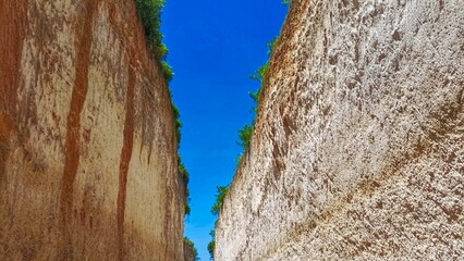 view of the clear sky during the day with gaps in the white limestone hills that are so high