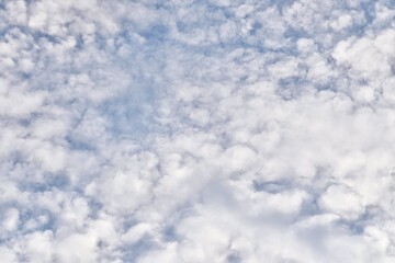 Fluffy white clouds texture on blue sky isolated on horizontal full frame background.