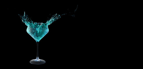Blue cocktail with splashes isolated on black background. Splashing blue cocktail on background with copy space.