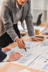 Business professionals analyzing financial charts and graphs during meeting, discussing data trends...