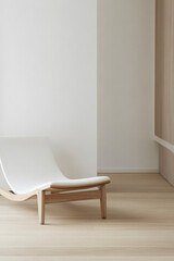 Modern lounge chair in minimalist interior space with warm wood flooring