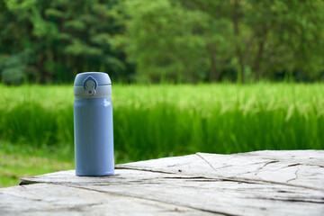 水田を背景にテーブルに置かれた水筒
