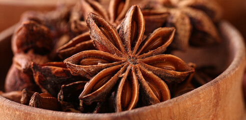 Wooden bowl with aromatic star anise, closeup