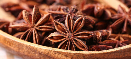 Wooden plate with aromatic star anise spice, closeup