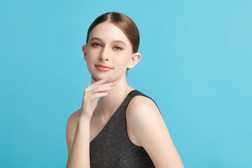 Beautiful young woman with clean fresh skin on blue background, Face care, Facial treatment, Cosmetology, beauty and spa, women portrait.
