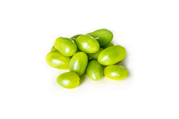 Closeup of fresh juicy organic green cherry tomatoes from the garden isolated on a white background focus on foreground