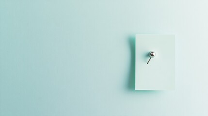 A pastel green note pinned with a shiny metallic push pin, neatly centered on a white background