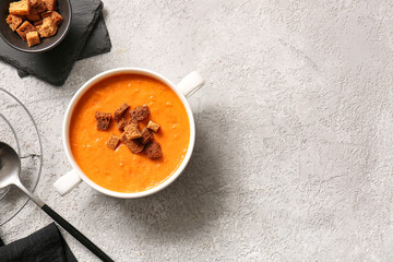 Pot of tasty cream soup with croutons on grey background