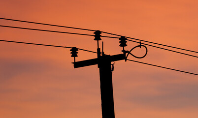 A tall power pole with wires hanging from it