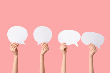 Female hands with speech bubbles on pink background