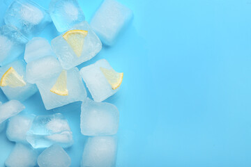 Frozen ice cubes and pieces of lemon on blue background