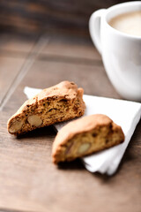 Cantuccini (Italian cookie) and a cup of coffee on dark wooden background. Close up.