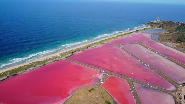 Breathtaking aerial view of the Salinas de Pampatar salt lagoons on Isla de Margarita, Venezuela. The red-hued salt pans and traditional harvesting methods highlight the area's unique natural beauty.