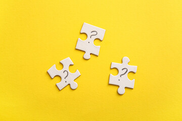Obraz premium Puzzle pieces with question marks on yellow background