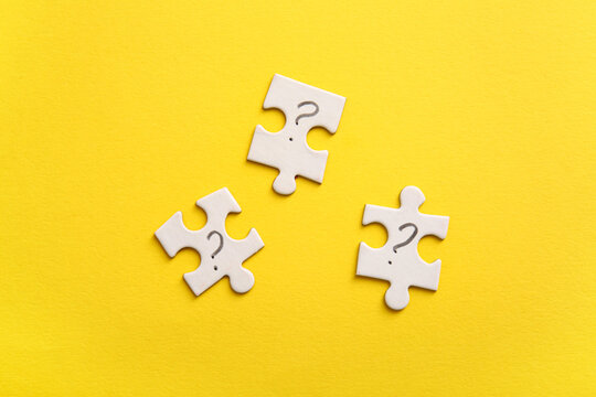 Puzzle pieces with question marks on yellow background