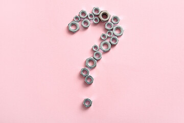 Question mark made of stainless steel nuts on pink background