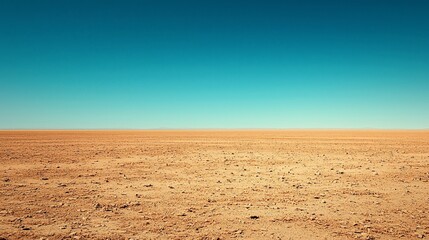 Fototapeta premium Vast, flat desert landscape under a clear blue sky.