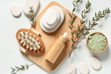 Plakat Composition with essential oil, massage brush, sea salt and spa stones on light background