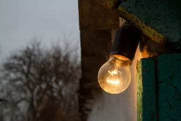 An old electric incandescent lamp for street lighting. Lighting of the village yard.