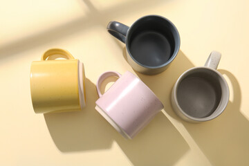 Set of stylish ceramic mugs on color background